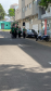 Quatro mulheres vestindo coletes verdes da Defensoria Pública caminham juntas e sorridentes por uma rua asfaltada. Elas seguram pastas e passam ao lado de veículos estacionados em uma área urbana.