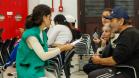 Imagem mostra servidora da DPE-PR realizando atendimento de família durante Mutirão Meu pai Tem Nome.  