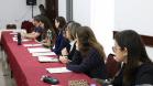 Na imagem vemos os participantes do II Encontro das Equipes Técnicas da DPPR sentados em uma mesa lateral comprida. Todos estão com um tanto virados para a direita, prestando atenção em quem fala. 