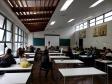 Em frente ao quadro, dra. Olenka Lins fala com os alunos que acompanham sua explicação.