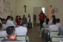 Dra. Cinthia Azevedo Santos está palestrando, no fundo de uma sala, na penitenciária feminina. 