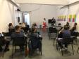 Na imagem vemos a equipe da DPPR palestrando aos guardas municipais. A equipe está de pé, ao fundo da sala, na frente dos oficias (esses estão sentados de costas).