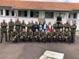 Vemos os soldados, alunos do curso, em fileiras - alguns abaixados e outros de pé - posando para foto. A equipe da DPPR da Casa da Mulher Brasileira se encontra em pé, no meio dos soldados, 