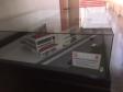 Na imagem vemos uma maquete do hospital do trabalho sendo exposta dentro de um envoltório de vidro. 