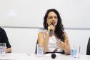 A imagem consiste da defensora pública Dra. Camile Vieira da Costa durante sua fala na mesa de abertura do evento.