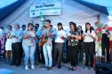 Garoto com violão enquanto os defensores estão no palco.