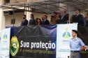 Palanque do evento com convidados na parte de cima da foto. Na parte de baixo, na direita, um aluno do Colégio Militar.  