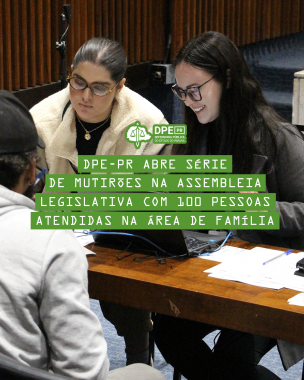 Imagem de duas mulheres da equipe da Defensoria atendendo a um homem, que está de costas. A mulher que está à direita, sorri. 