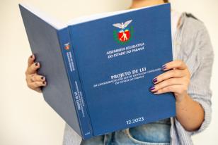Imagem com foto de mulher segurando a edição física da lei que instituiu o Código Paranaense de Defesa do Consumidor.