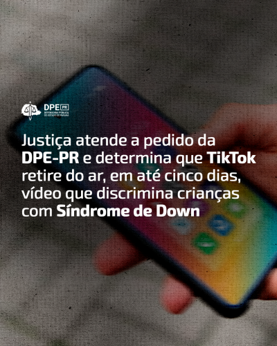 Imagem da tela de um celular desfocada com textura que imita papel. Alinhado à esquerda e em branco, o título da matéria "Justiça atende a pedido da DPE-PR e determina que TikTok retire do ar, em até cinco dias, vídeo que discrimina crianças com Síndrome de Down". Acima o logo da Defensoria em branco