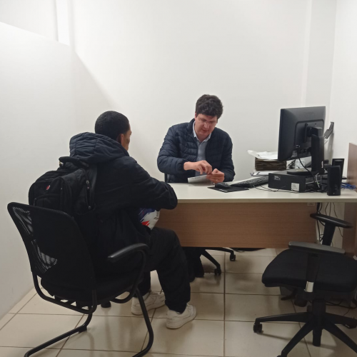 Imagem do defensor Ricardo atendendo um homem, em uma sala.