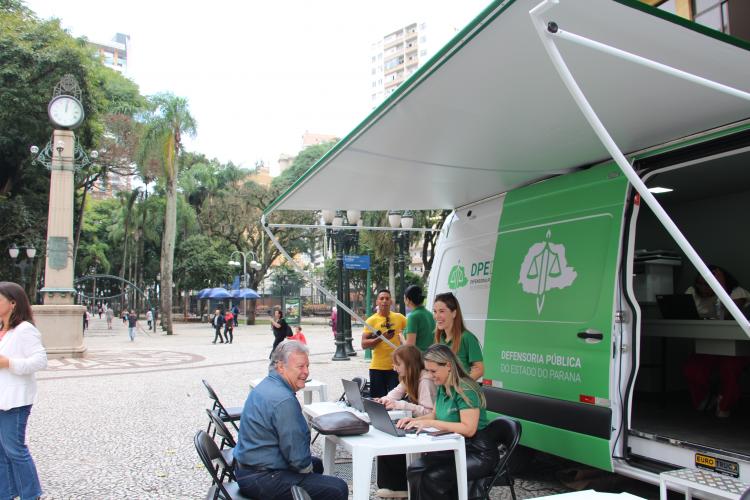 Imagem com foto de atendimento da DPE-PR com a Van dos Direitos.