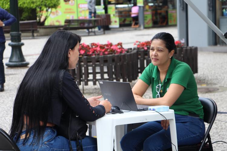 Imagem com foto de atendimento da DPE-PR com a Van dos Direitos.