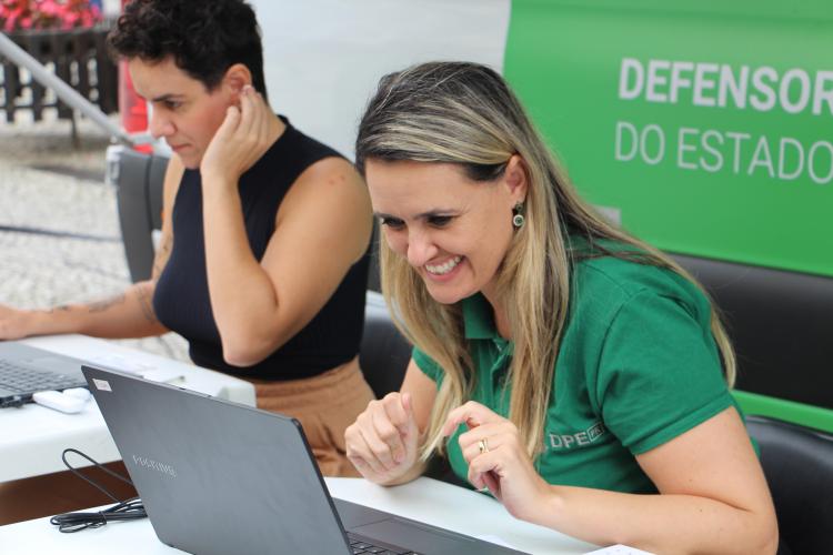 Imagem com foto de atendimento da DPE-PR com a Van dos Direitos.