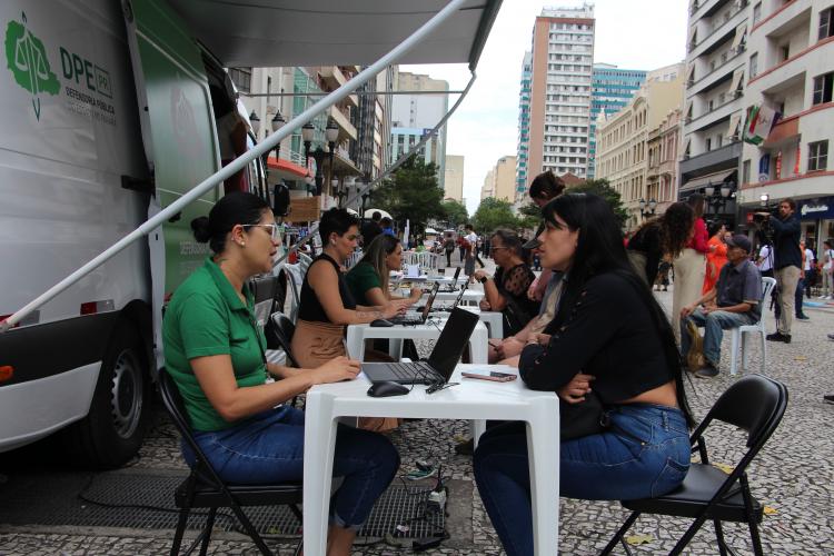 Imagem com foto de atendimento da DPE-PR com a Van dos Direitos.