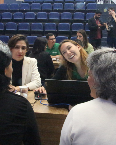 Imagem de duas defensoras sorrindo enquanto atendem duas mulheres.