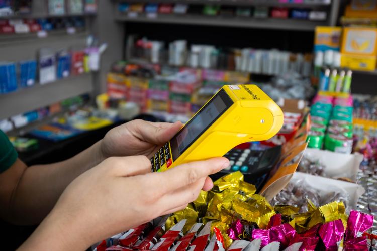 Imagem com foto de transação realizada em máquina de cartão de débito e crédito em estabelecimento comercial.