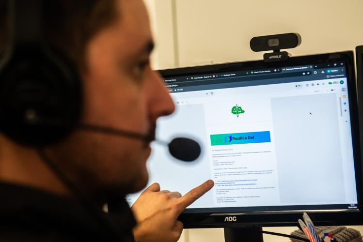 Imagem com foto de mediador da Defensoria, em frente a uma tela do Pacifica.Def.