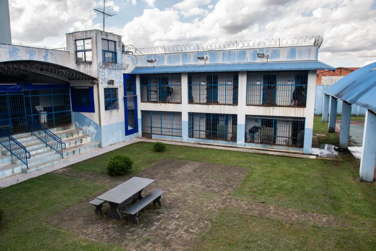 Imagem que mostra o pátio interno de um centro de socioeducação, fotografado de um ponto de vista elevado. O local é cercado por edificações que reforçam a natureza de segurança da instituição.