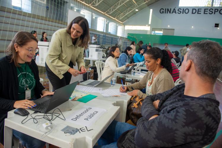 Imagem mostra Defensora Pública e Servidora realizando atendimento de casal durante mutirão.