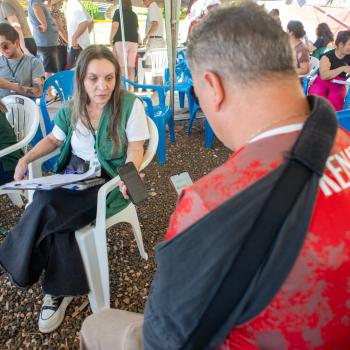 Defensora Pública atende homem com tipoia vítima do tornado.