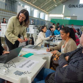 Imagem mostra Defensora Pública e Servidora realizando atendimento de casal durante mutirão. 
