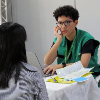 Servidora da DPE-PR realiza atendimento de uma mulher durante Mutirão em Maringá.  