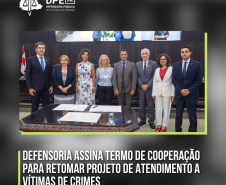 Foto mostra oito pessoas lado a lado e em frente a uma mesa. Na imagem, um título onde se lê: Defensoria assina Termo de Cooperação para retomar projeto de atendimento a vítimas de crimes