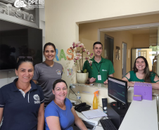 Imagem do grupo de pessoas que realizou o atendimento no mutirão em Floresta. Entre as pessoas estão um homem branco com a camiseta verde com o logo da Defensoria em branco, uma mulher branca com uma camisa verde e três servidoras do CRAS, todas brancas com camisetas da azuis.