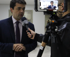 Imagem com foto do Defensor Público-Geral do Paraná, André Ribeiro Giamberardino, concedendo entrevista.