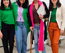 Imagem que mostra as defensoras públicas que atuaram no mutirão junto de uma mulher que foi atendida.
