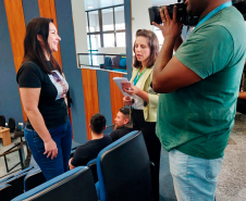 Imagem que mostra o momento no qual uma usuária da DPE-PR é entrevistada. A usuária sorri enquanto fala para a câmera.