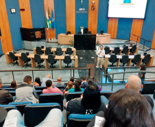 Imagem que mostra o defensor Fernando Redede falando para pessoas que aguardam atendimento para a entrega de DNA.