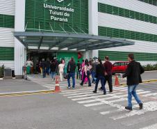 Imagem que mostra candidatos e candidatas entrando no prédio principal da Universidade Tuiuti, em Curitiba, um dos locais de prova.