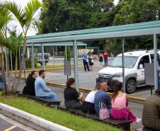 Imagem que mostra candidatos e candidatas sentados em frente ao prédio principal da Universidade Tuiuti, em Curitiba, um dos locais de prova.