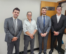 Imagem que mostra a inauguração da sala da DPE-PR em Cruzeiro do Oeste. Representantes da Defensoria posam em frente à porta da sala da DPE-PR, do lado de dentro da sala.