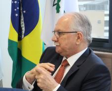 Imagem com a foto do Ministro Fachin sentado à mesa  com as bandeiras do Brasil e da Defensoria ao fundo.