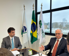 Imagem com a foto do Ministro Fachin sentado à mesa ao lado do Defensor Público-Geral, André  outras personalidades representantes das catergorias e setores da Defensoria.