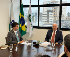 Imagem com a foto do Ministro Fachin sentado à mesa ao lado do Defensor Público-Geral, André  outras personalidades representantes das catergorias e setores da Defensoria.