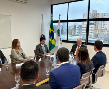 Imagem com a foto do Ministro Fachin sentado à mesa com personalidades representantes das catergorias da Defensoria.