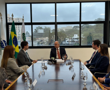 Imagem com a foto do Ministro Fachin sentado à mesa com personalidades representantes das catergorias da Defensoria.