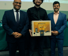 Imagem com uma foto do ganhador de melhor tese, Gabriel Roque, junto do diretor da EDEPAR e do Presidente da Adepar.
