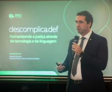 Foto mostrando o Defensor Público-Geral do Estado do Paraná, Matheus Cavalcanti Munhoz, apresentando o projeto descomplica.def, projeto que humaniza a justiça através da tecnologia e da linguagem.