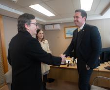 Imagem do Defensor Público-Geral, Matheus Munhoz, acompanhado da 1° subdefensora pública, Lívia Brodbeck, cumprimentando o diretor-geral da Polícia Científica, Luiz Rodrigo Grochocki.