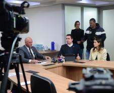 Imagem com o diretor-geral da Polícia Científica, Luiz Rodrigo Grochocki, juntamento do secretário de Segurança Pública, Hudson Leôncio Teixeira,  e do Defensor Público-Geral, Matheus Munhoz, sentados em uma mesa e se pronunciando durante a coletiva de imprensa