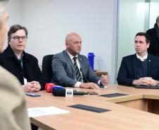 Imagem com o diretor-geral da Polícia Científica, Luiz Rodrigo Grochocki, juntamento do secretário de Segurança Pública, Hudson Leôncio Teixeira,  e do Defensor Público-Geral, Matheus Munhoz, sentados em uma mesa e se pronunciando durante a coletiva de imprensa