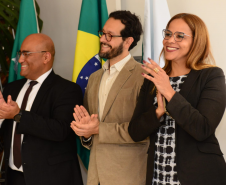 Imagem com defensores sorrindo e batendo palma durante a cerimônia