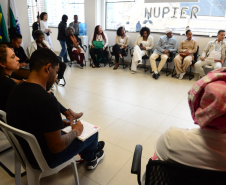 imagem com diversas pessoas representantes de coletivos negros sentados durante a roda de conversa com o NUPIER