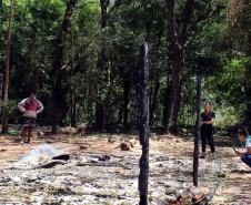 Imagem colorida horizontal em que se vê a equipe da DPE-PR verificando casa queimada na aldeia durante os conflitos com indígenas em Guaíra.  