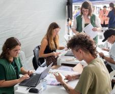 Imagem horizontal colorida em que aparece a equipe da DPE-PR realizando os atendimentos do Mutirão. 